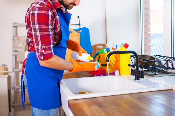 Der Mensch putzt die Küche. junger Mann spült das Geschirr. Das ist nicht der Fall. — Stockfoto