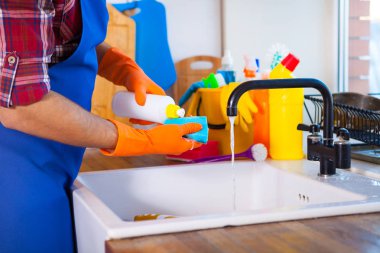 Adam mutfağın temizlik yapar. Genç adam bulaşıkları yıkar. Cle