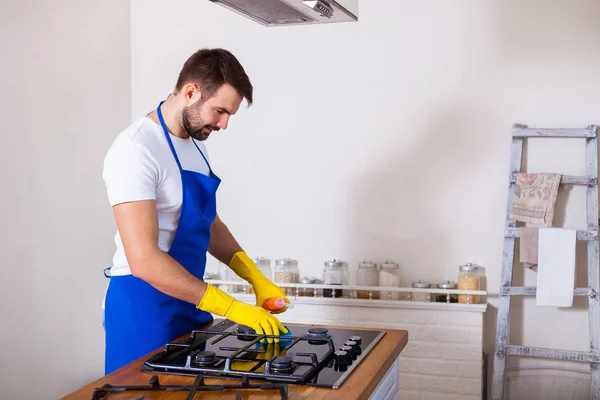 Hombres jóvenes en goma de limpieza protectora y cocina pulida. Negro — Foto de Stock