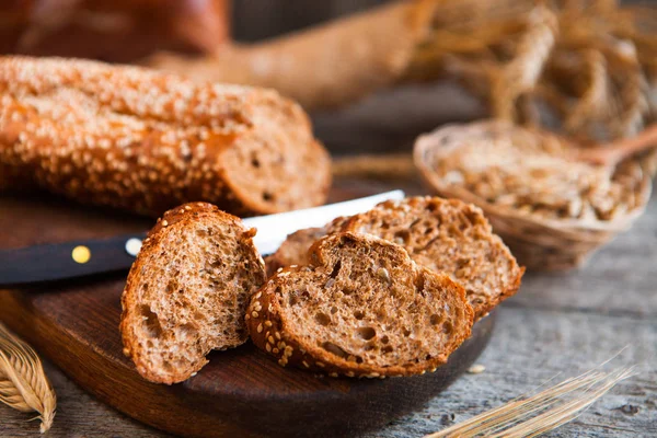 Pan de centeno rebanado en una tabla. Sobre una mesa rústica de madera . — Foto de Stock