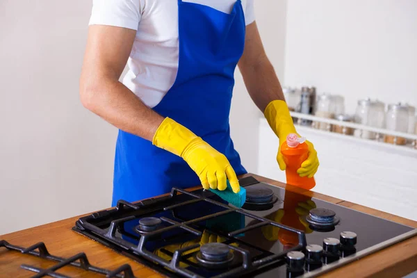 Jonge mannen in rubber beschermende reinigen en polijsten fornuis. Zwart — Stockfoto