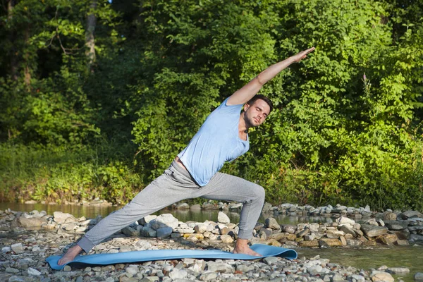 Hombre meditando cerca del río de la montaña. Yoga practicando al aire libre — Foto de Stock