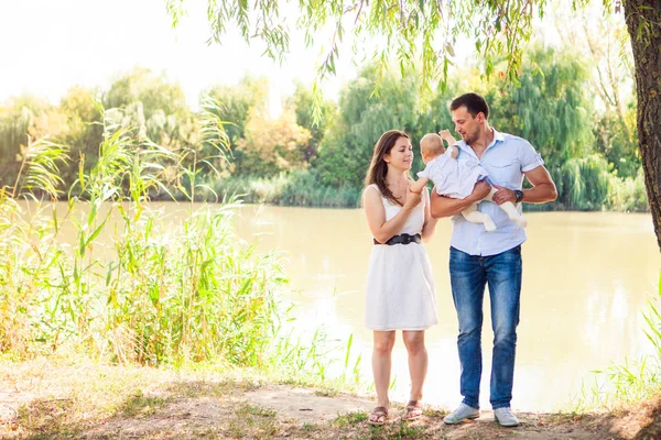 Glückliche junge Familie verbringt Zeit im Freien an einem Sommertag, Picknick — Stockfoto