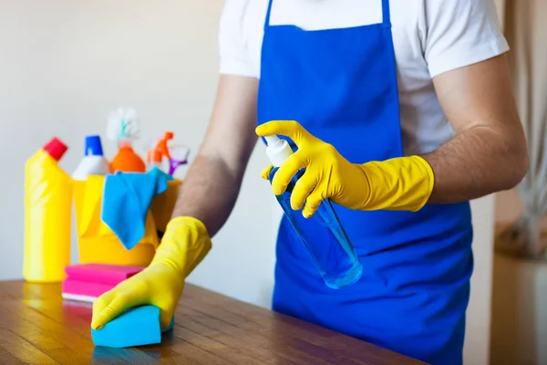 Nahaufnahme eines jungen Mannes mit Schürze, der Küchenarbeitsplatte putzt — Stockfoto