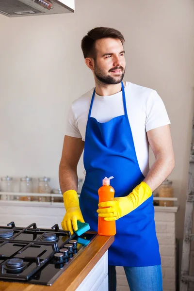 Jonge mannen in rubber beschermende reinigen en polijsten fornuis. Zwart — Stockfoto