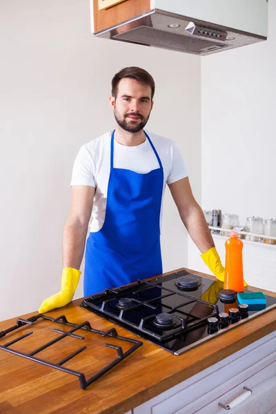 Jonge mannen in rubber beschermende reinigen en polijsten fornuis. Zwart — Stockfoto