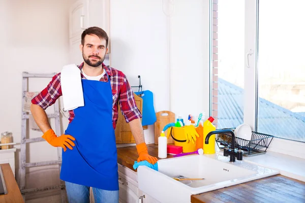 Ο άνθρωπος κάνει το καθάρισμα της κουζίνας. Νεαρός άνδρας πλένει τα πιάτα. CLE — Φωτογραφία Αρχείου