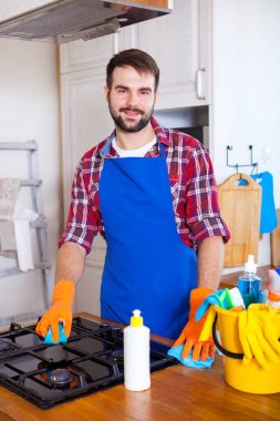 Adam mutfağın temizlik yapar. Genç adam bir fırın yıkar. Cleani