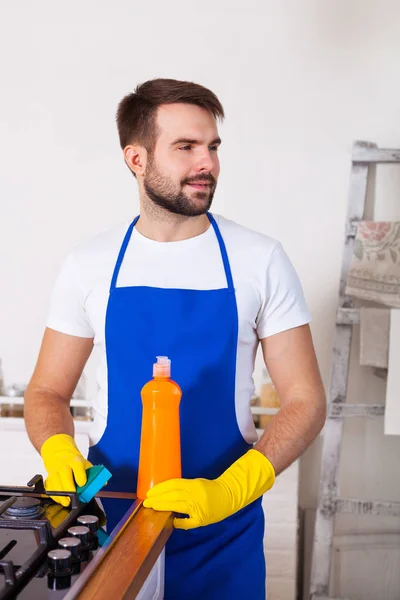 Jeunes hommes en caoutchouc de nettoyage protecteur et cuisinière à polir. Noir — Photo