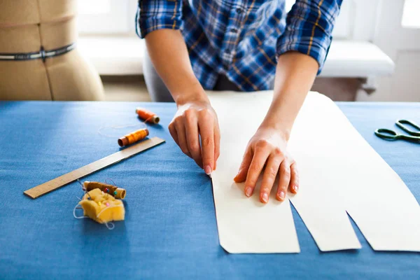 Hands woman Tailor working cutting a roll of fabric on which she — Stock Photo, Image