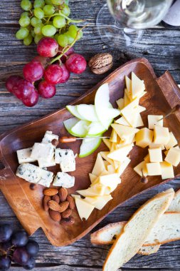 Şarap yemek saati ayarlayın. Bardak beyaz şarap, üzüm ve çeşitli türlü ch