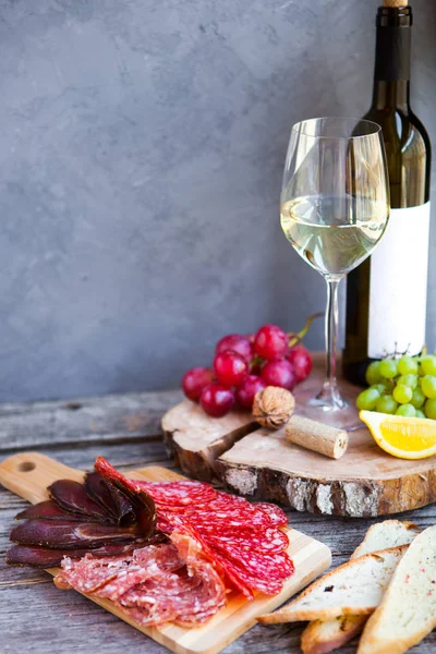 Vaso con vino blanco, uva, queso, sobre fondo rústico de madera — Foto de Stock