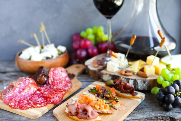 Lanche de vinho pronto. Copo de vinho tinto, uva, queijo, sobre wo rústico — Fotografia de Stock