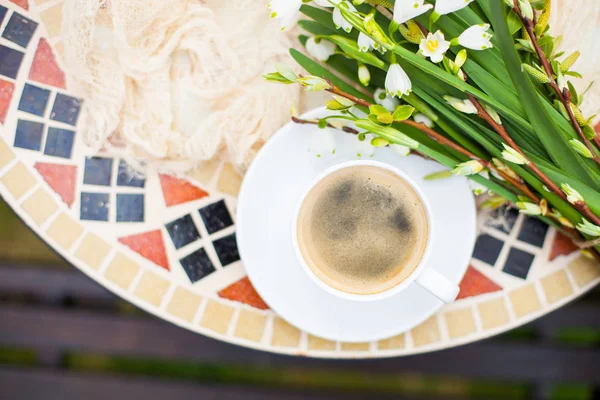 Bouquet Bunga lonceng musim semi putih dan cangkir kopi di atas meja di gar — Stok Foto