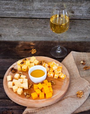 Üzüm, peynir, incir ve bal bir kadeh beyaz şarap ile woo