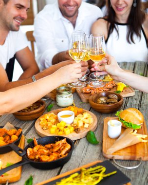 Kırmızı şarap gıda ile sunulan tablo üzerinde toasting ile eller.