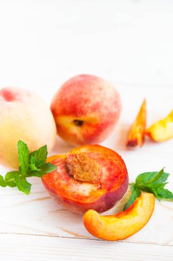 Ahşap beyaz zemin üzerine nane ile taze şeftali.