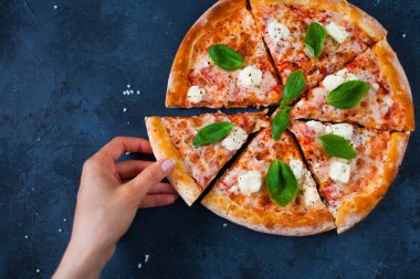 Sıcak pizza bir dilim el tutar