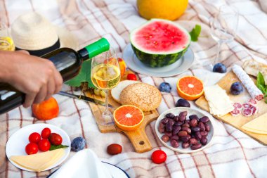 Yeşil çimenlerin üzerinde yaz piknik sepeti. Yiyecek ve içecek konsepti.