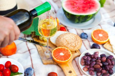 Yeşil çimenlerin üzerinde yaz piknik sepeti. Yiyecek ve içecek konsepti.