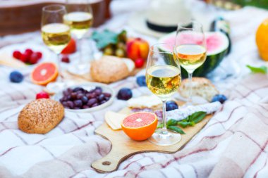 Yeşil çimenlerin üzerinde yaz piknik sepeti. Yiyecek ve içecek konsepti.