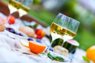 Yeşil çimenlerin üzerinde yaz piknik sepeti. Yiyecek ve içecek konsepti.