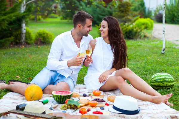 Gelukkige paar verliefd op een plaid picknick in het park — Stockfoto