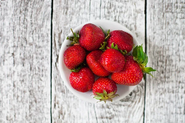 Eski ahşap beyaz masa üzerinde taze çilek
