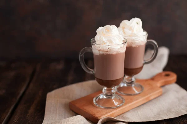 Warme chocolademelk gegarneerd met geranselde room en cacao poeder. — Stockfoto