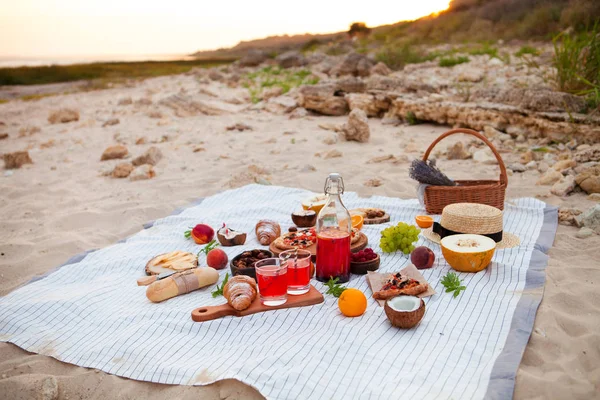 Piquenique na praia ao pôr do sol na planície branca, comida e bebida — Fotografia de Stock