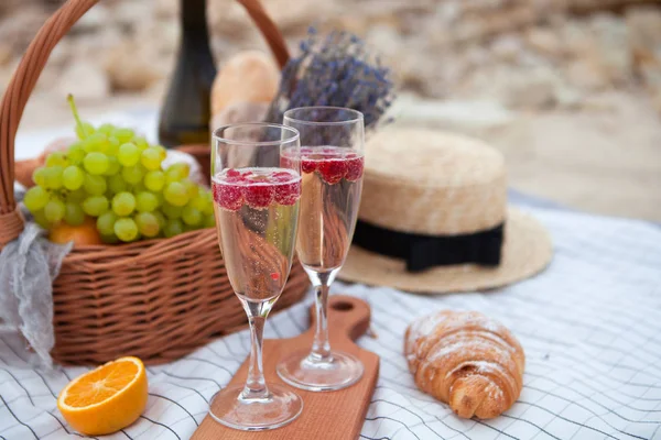 Dwie szklanki szampana. Piknik na plaży o zachodzie słońca w w — Zdjęcie stockowe