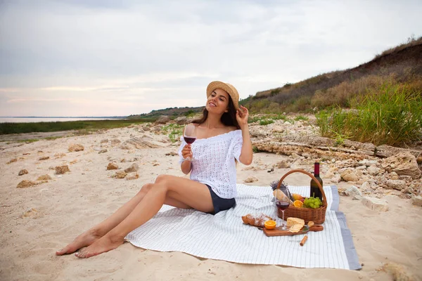 Woman in summer Picnic on the beach at sunset in the white plaid — Stock Photo, Image