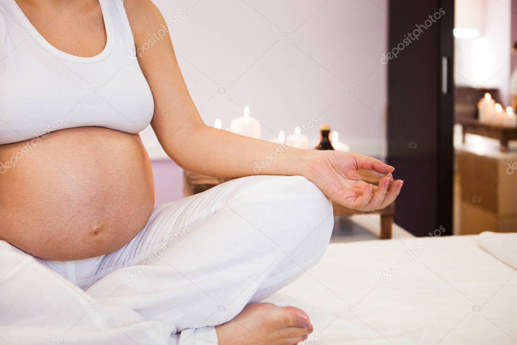 Meditating on maternity. Close-up of pregnant woman meditating w