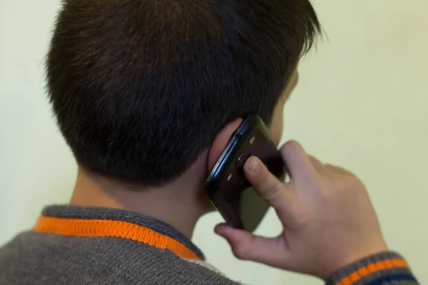 Fechar-se de menino de idade jovem chamando smartphone — Fotografia de Stock
