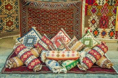 El ile yapılan birçok değerli antik renkli yün Azeri halı sahte ve antik yastık