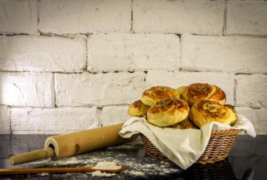 Rustik tuğla beyaz arka plan ile sepet üzerinde taze ev yapımı çörekler.