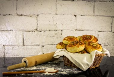 Rustik tuğla beyaz arka plan ile sepet üzerinde taze ev yapımı çörekler.