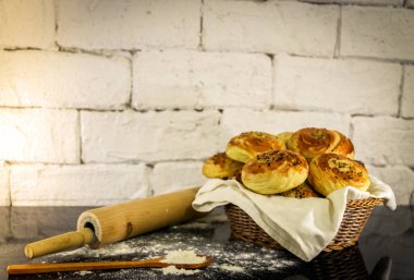 Rustik tuğla beyaz arka plan ile sepet üzerinde taze ev yapımı çörekler.