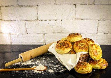 Rustik tuğla beyaz arka plan ile sepet üzerinde taze ev yapımı çörekler.