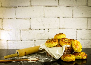 Rustik tuğla beyaz arka plan ile sepet üzerinde taze ev yapımı çörekler.