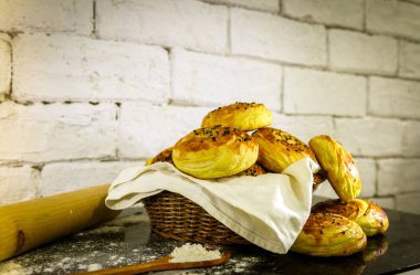 Rustik tuğla beyaz arka plan ile sepet üzerinde taze ev yapımı çörekler.