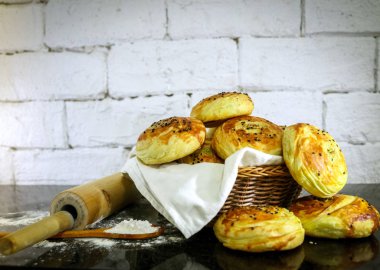 Rustik tuğla beyaz arka plan ile sepet üzerinde taze ev yapımı çörekler.