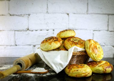 Rustik tuğla beyaz arka plan ile sepet üzerinde taze ev yapımı çörekler.