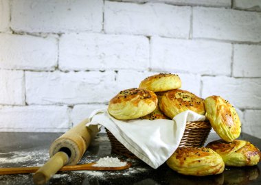 Rustik tuğla beyaz arka plan ile sepet üzerinde taze ev yapımı çörekler.