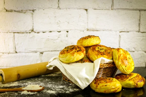 Rustik tuğla beyaz arka plan ile sepet üzerinde taze ev yapımı çörekler.