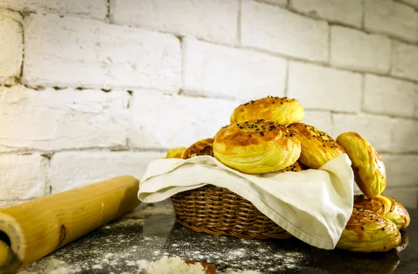 Rustik tuğla beyaz arka plan ile sepet üzerinde taze ev yapımı çörekler.