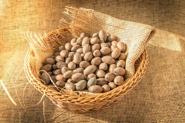 Pecan in cesto avvolto con tessuto di iuta con luce solare mattutina dalla finestra . — Foto Stock