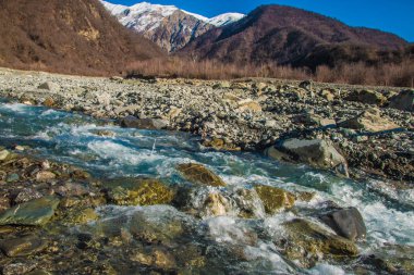 Akarsu nehir ve dağ manzarası. Gün ışığında karlı tepe