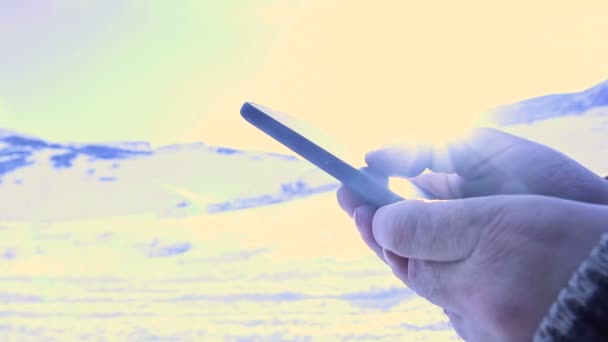 Man searching something on smartphone at mountain peak. Swiping with hand on cellphone. — Stock Video