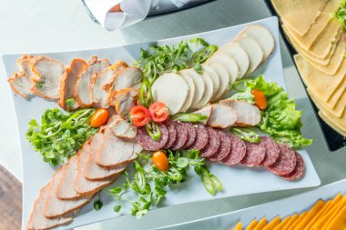 Sosis, Yeşiller ve diğer salata beyaz tablo tablo. Kavram catering.